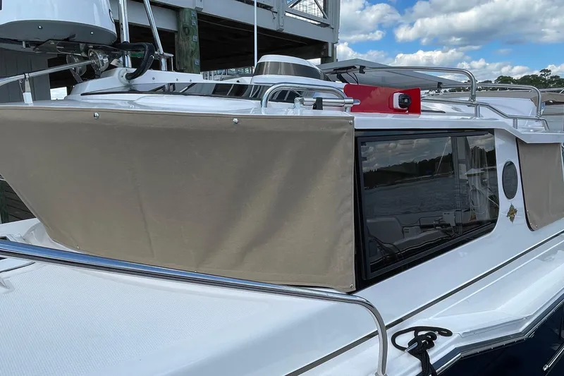 Slide: The Image of 2025 Ranger Tugs R-27 Seakeeper Ride boat with beige canvas cover and sleek design. - 3