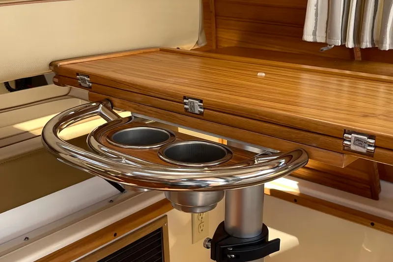 Slide: The Image of 2025 Ranger Tugs R-27 Seakeeper Ride interior with wooden table and stainless steel cup holders. - 31