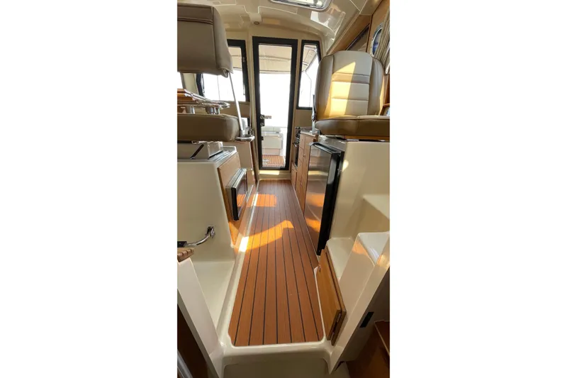 Slide: The Image of Interior of 2025 Ranger Tugs R-27 Seakeeper Ride, featuring elegant wood flooring and modern design. - 33