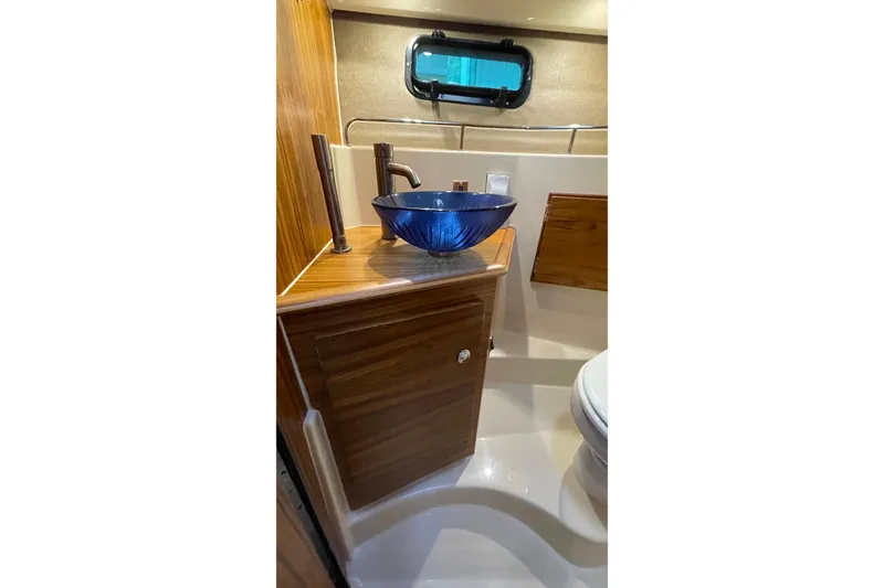 Slide: The Image of Luxurious bathroom in 2025 Ranger Tugs R-27 Seakeeper Ride with blue glass sink. - 36