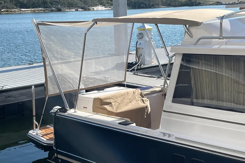 Slide: The Image of 2025 Ranger Tugs R-27 Seakeeper Ride docked, featuring a shaded deck area. - 6