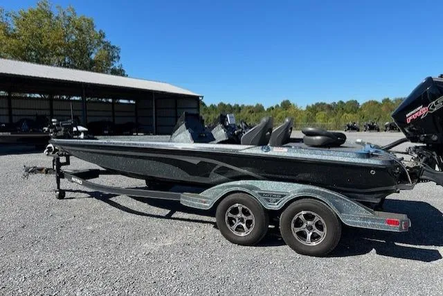 Slide: The Image of 2024 Nitro Z21 boat on trailer, parked outdoors under clear blue sky. - 6