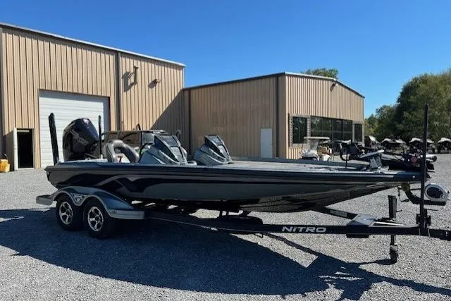 Slide: The Image of 2024 Nitro Z21 boat on trailer, parked outside a warehouse under clear blue sky. - 8