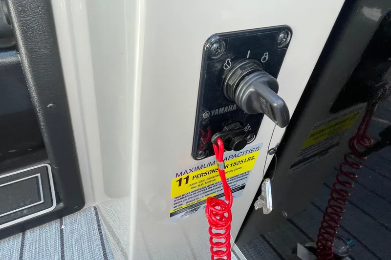 Slide: The Image of 2026 SunCatcher Select 322SL pontoon boat interior with red and white seating, docked outdoors. - 15