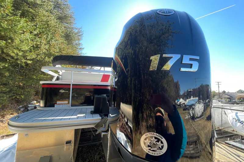 Slide: The Image of 2026 SunCatcher Select 322SL boat interior with gray and red seating on deck. - 22