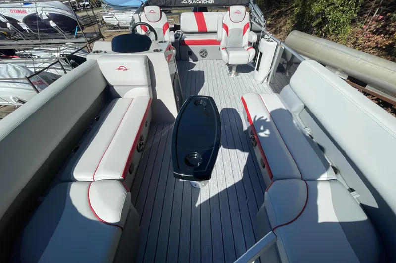 Slide: The Image of 2026 SunCatcher Select 322SL boat interior with red and white seating, docked outdoors. - 6