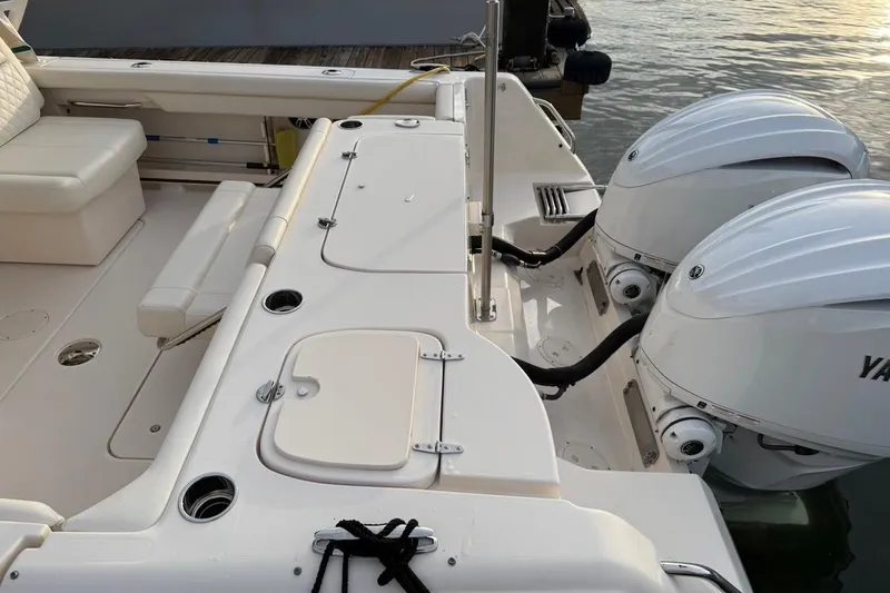 Slide: The Image of 2022 Grady-White Freedom 307 boat with dual Yamaha outboard engines, docked by the water. - 14