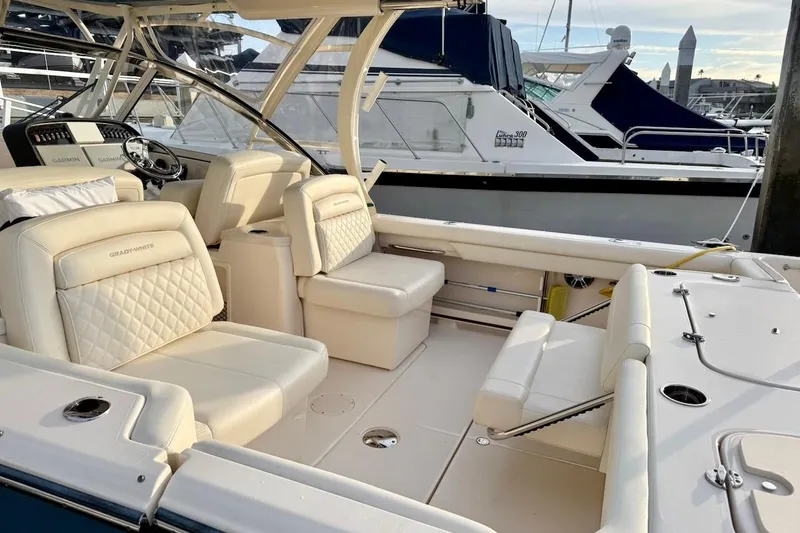 Slide: The Image of 2022 Grady-White Freedom 307 boat interior with luxurious seating and helm, docked at marina. - 16