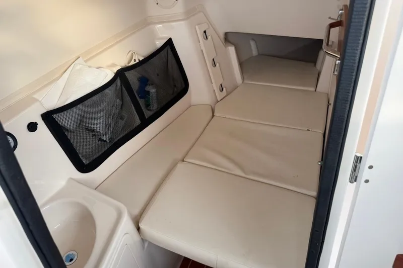 Slide: The Image of 2022 Grady-White Freedom 307 cabin interior with cushioned seating and storage. - 24