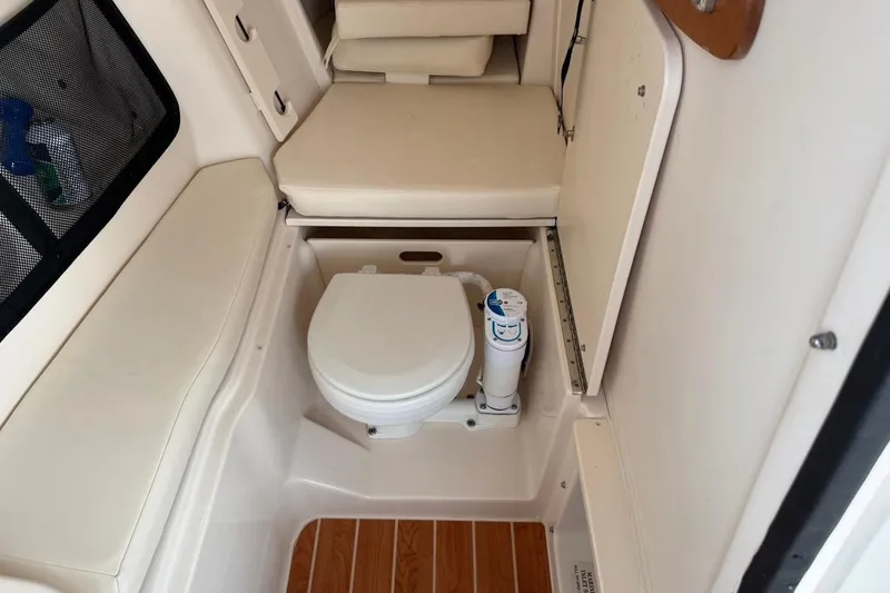 Slide: The Image of 2022 Grady-White Freedom 307 boat interior with compact marine toilet and seating. - 25