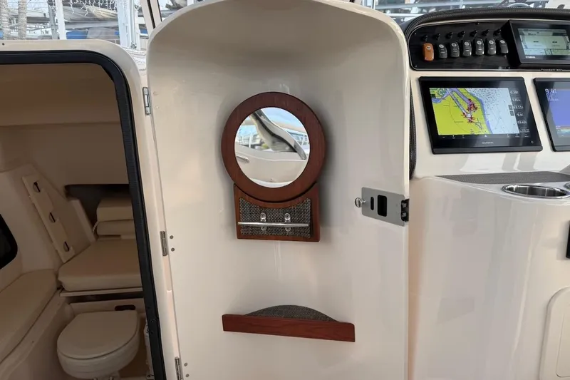 Slide: The Image of 2022 Grady-White Freedom 307 boat interior with navigation screens and cabin view. - 26