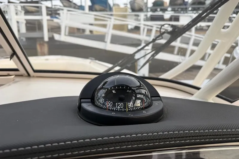 Slide: The Image of Compass on 2022 Grady-White Freedom 307 boat dashboard, docked at marina. - 43