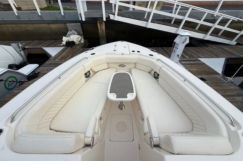 Slide: The Image of 2022 Grady-White Freedom 307 boat interior with white seating and table at dock. - 44