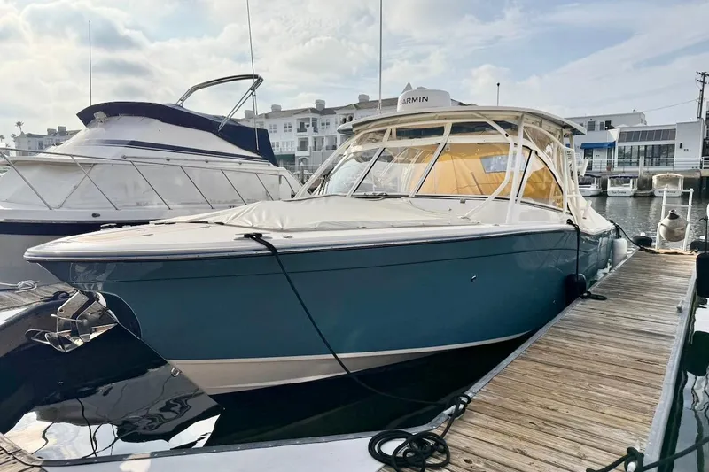 Slide: The Image of 2022 Grady-White Freedom 307 boat docked at marina under cloudy sky. - 5