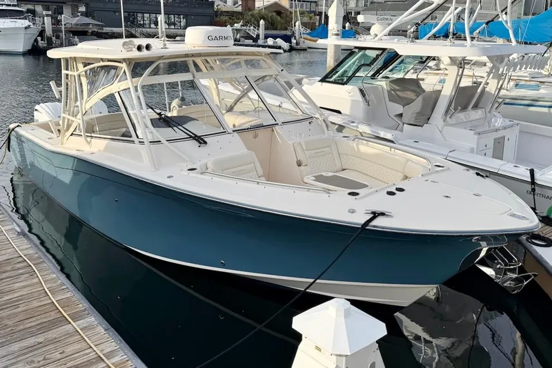 Slide: The Image of 2022 Grady-White Freedom 307 boat docked in marina, featuring sleek design and spacious seating. - 6
