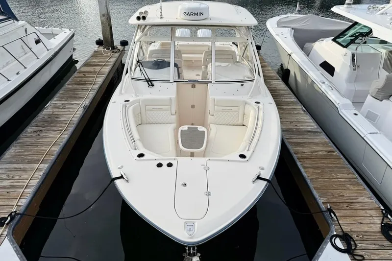Slide: The Image of 2022 Grady-White Freedom 307 boat docked, featuring spacious seating and Garmin equipment. - 7