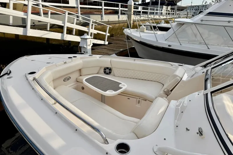 Slide: The Image of 2022 Grady-White Freedom 307 boat with luxurious seating and table, docked at marina. - 8