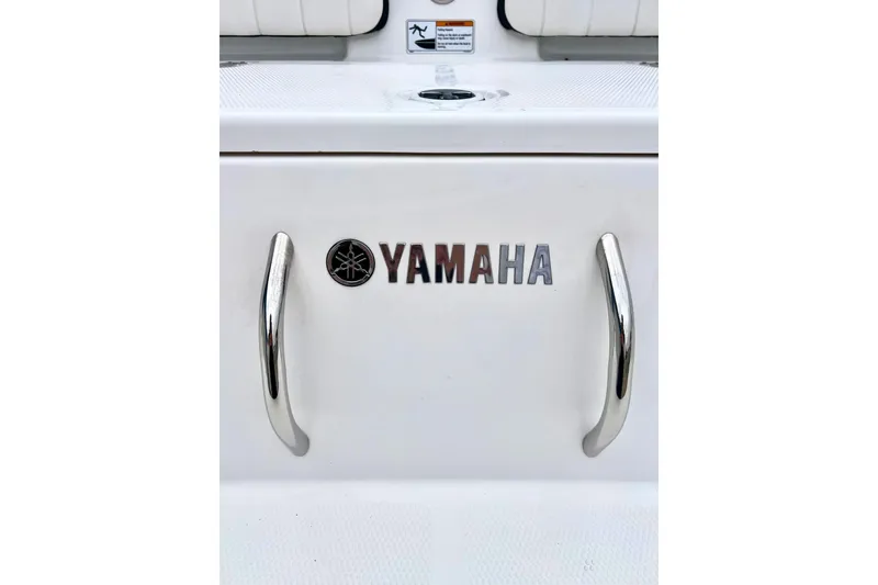 Slide: The Image of 2022 Yamaha Boats 255 FSH Sport H logo with chrome handles on white surface. - 10