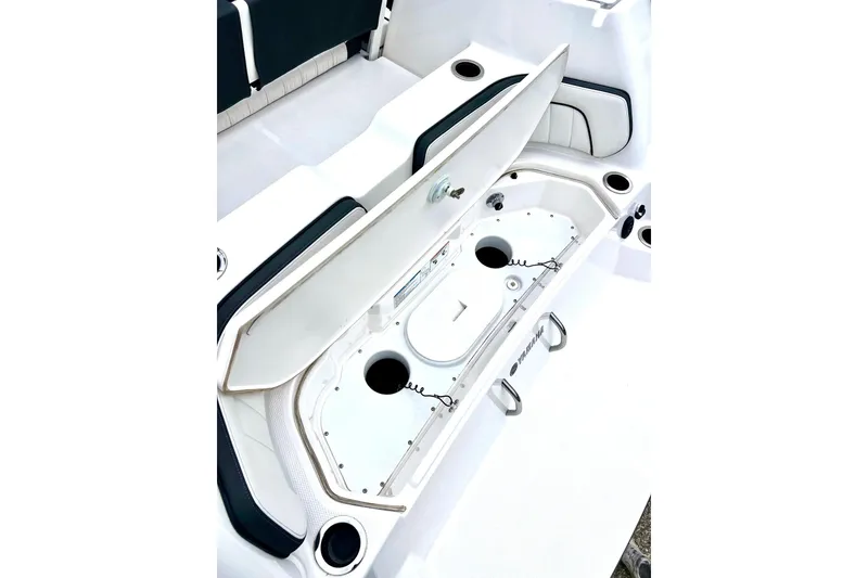 Slide: The Image of 2022 Yamaha Boats 255 FSH Sport H open storage compartment, showcasing interior design. - 14