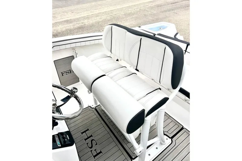 Slide: The Image of 2022 Yamaha Boats 255 FSH Sport H interior seating with sleek white and black design. - 19