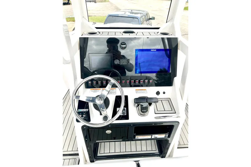 Slide: The Image of 2022 Yamaha Boats 255 FSH Sport H dashboard with steering wheel and control panel. - 2