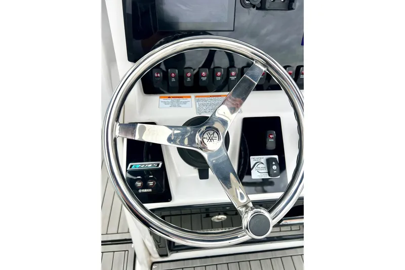 Slide: The Image of Steering wheel of 2022 Yamaha Boats 255 FSH Sport H, featuring control panel. - 4