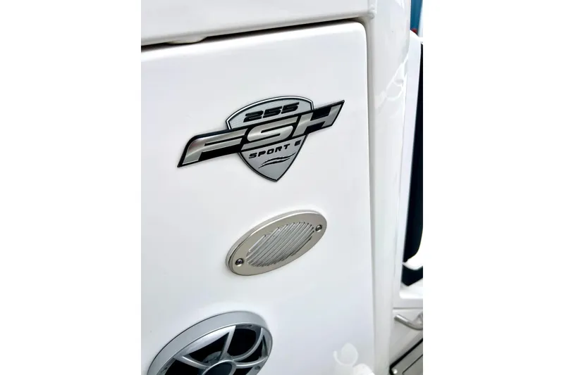 Slide: The Image of 2022 Yamaha Boats 255 FSH Sport H logo on white surface with speaker detail. - 47