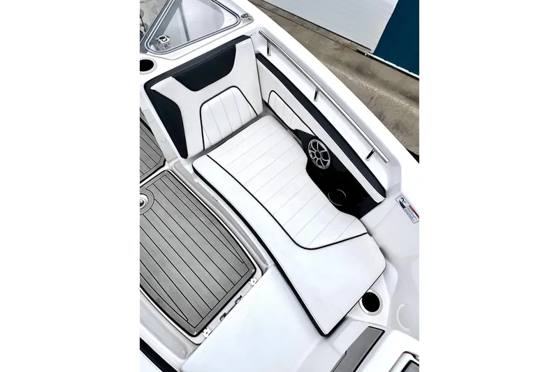 Slide: The Image of 2022 Yamaha Boats 255 FSH Sport H interior with white cushioned seating and sleek design. - 51