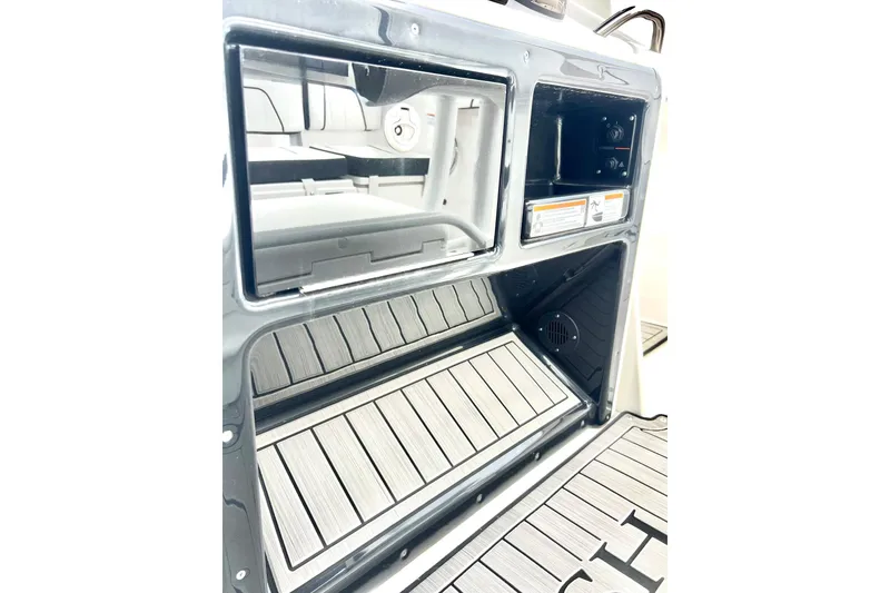 Slide: The Image of 2022 Yamaha Boats 255 FSH Sport H interior with storage compartments and non-slip flooring. - 67