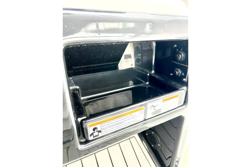 Slide: The Image of 2022 Yamaha Boats 255 FSH Sport H storage compartment with control panel. - 69