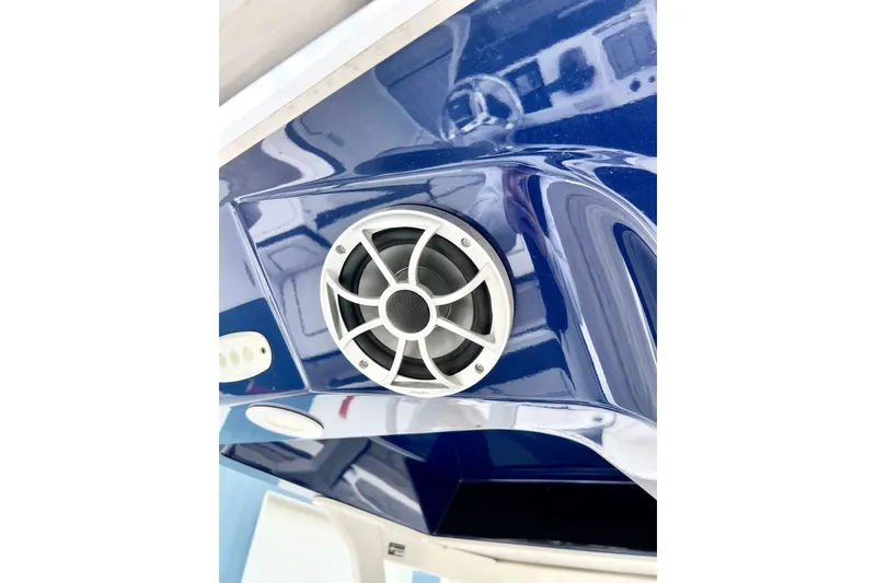 Slide: The Image of Close-up of a 2022 Yamaha Boats 255 FSH Sport H speaker on a blue hull. - 76