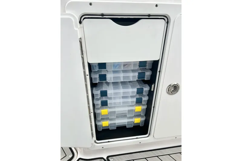 Slide: The Image of Storage compartment with tackle boxes on a 2022 Yamaha Boats 255 FSH Sport H. - 82