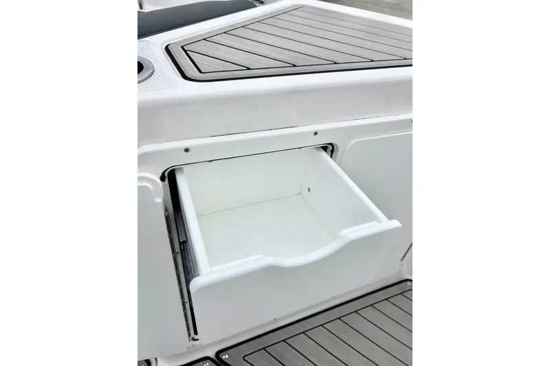Slide: The Image of 2022 Yamaha Boats 255 FSH Sport H storage compartment with open drawer. - 83