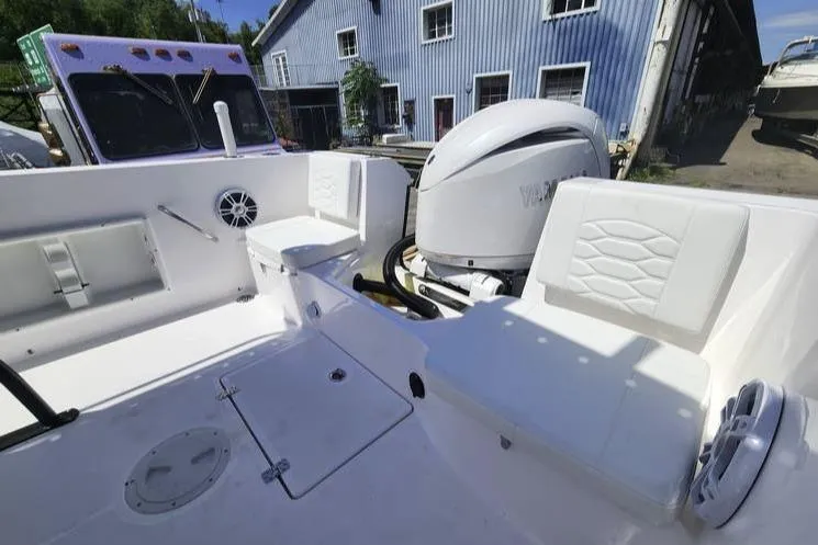 Slide: The Image of 2024 Aquasport 2100 Center Console boat interior with seating and Yamaha engine. - 2