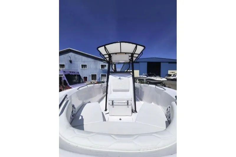 Slide: The Image of 2024 Aquasport 2100 Center Console boat with T-top, docked near blue buildings. - 6