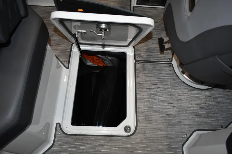 Slide: The Image of 2023 Cobalt R8 boat storage compartment with open lid and visible interior items. - 23