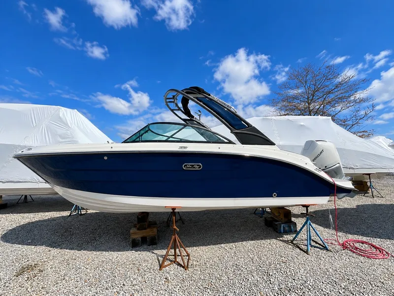 Slide: The Image of A 2026 Sea Ray SDX 230 Outboard is on a gravel lot, supported by stands. - 1