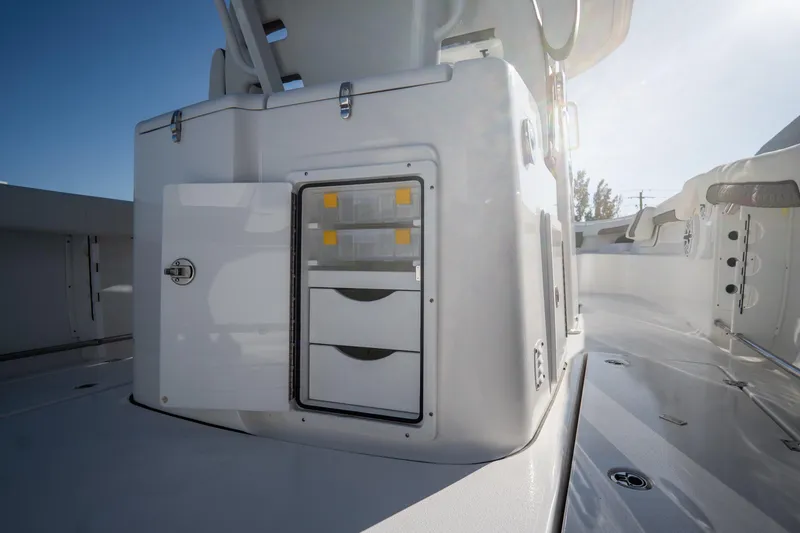 Slide: The Image of 2021 Tidewater 320 CC Adventure boat docked, featuring rod holders and a Garmin system. - 15