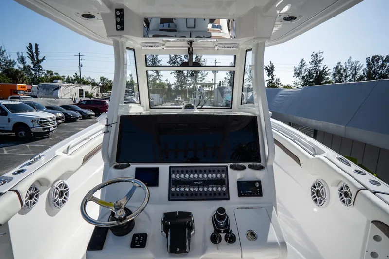 Slide: The Image of Tidewater 320 CC Adventure 2021 boat T-top with speakers against blue sky. - 22