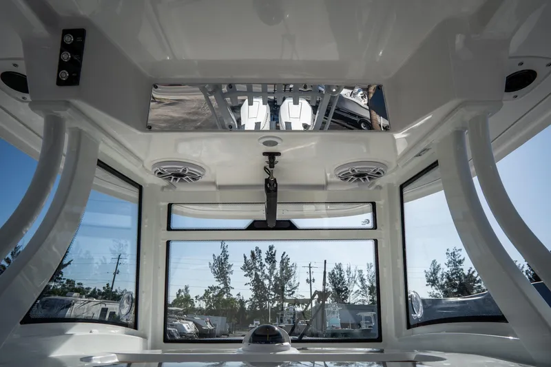 Slide: The Image of 2021 Tidewater 320 CC Adventure boat interior with Garmin navigation, docked near waterfront homes. - 28