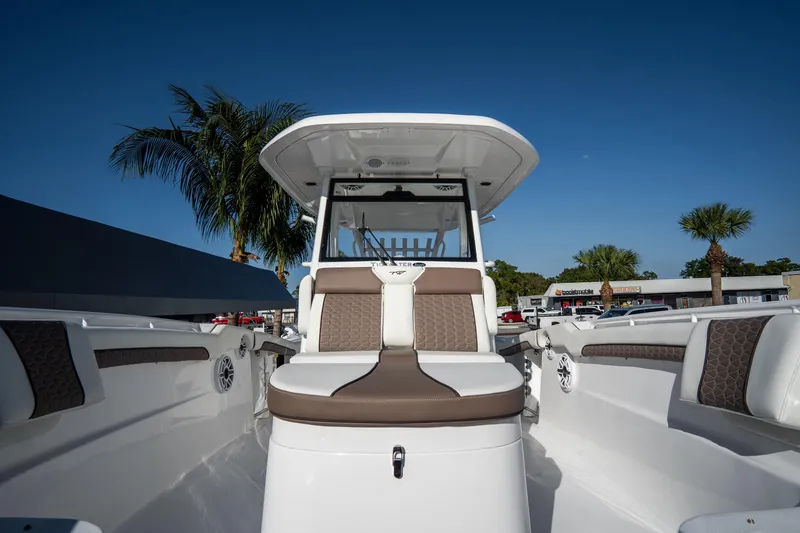 Slide: The Image of 2021 Tidewater 320 CC Adventure boat interior with seating, palm trees, and waterfront view. - 38