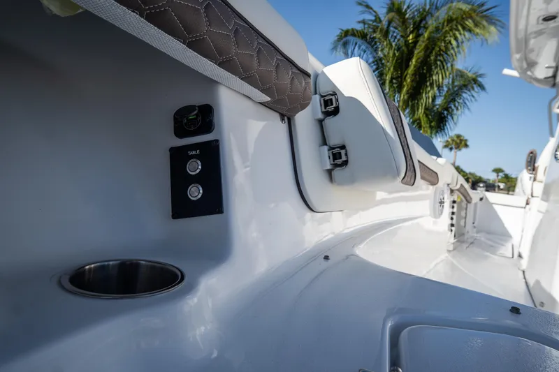 Slide: The Image of 2021 Tidewater 320 CC Adventure boat interior with cushioned seating and speakers. - 52