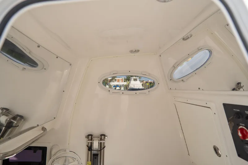 Slide: The Image of Interior cabin of 2021 Tidewater 320 CC Adventure boat, featuring porthole windows and control panel. - 67
