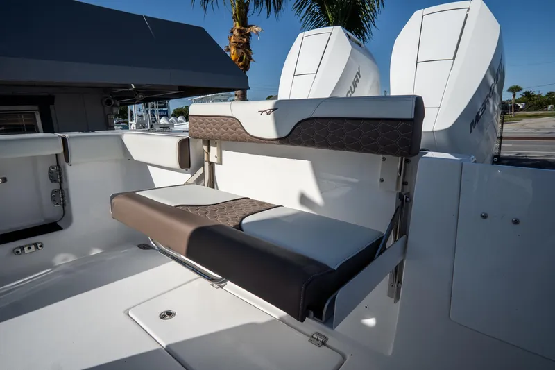 Slide: The Image of 2021 Tidewater 320 CC Adventure boat interior with seating and storage, docked by the water. - 9