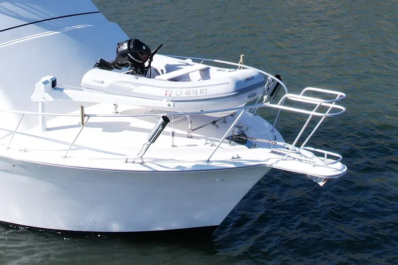 Slide: The Image of 1996 Egg Harbor 35 Sport Fisherman with dinghy on bow, anchored in water. - 12
