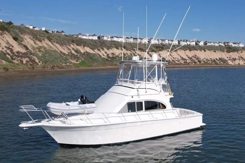Slide: The Image of 1996 Egg Harbor 35 Sport Fisherman yacht cruising near scenic coastal cliffs. - 3