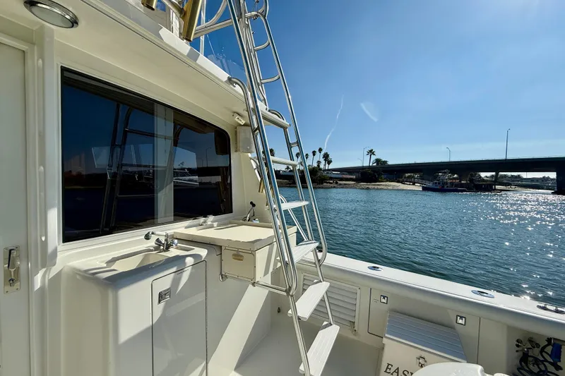 Slide: The Image of 1996 Egg Harbor 35 Sport Fisherman boat with ladder, sink, and scenic waterfront view. - 42