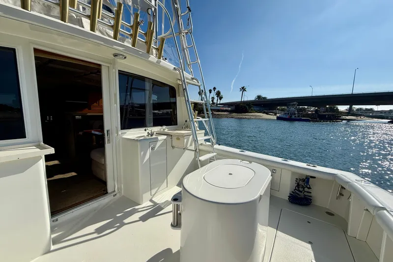 Slide: The Image of 1996 Egg Harbor 35 Sport Fisherman boat on water, featuring spacious deck and ladder. - 48