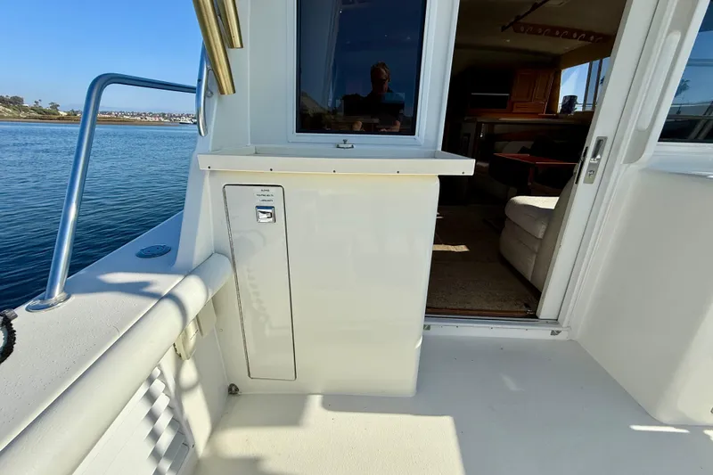 Slide: The Image of 1996 Egg Harbor 35 Sport Fisherman boat interior with open cabin door, docked by the water. - 50