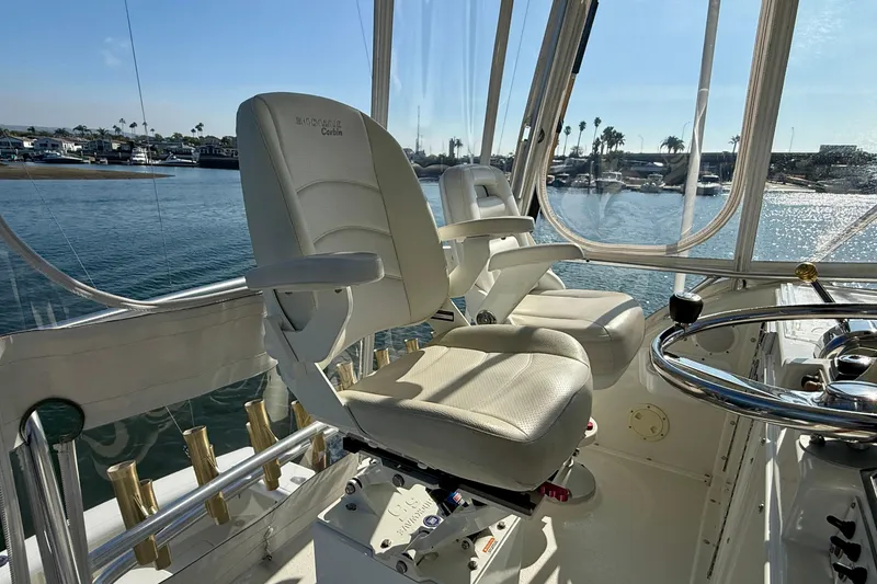 Slide: The Image of 1996 Egg Harbor 35 Sport Fisherman helm with white captain chairs and waterfront view. - 66